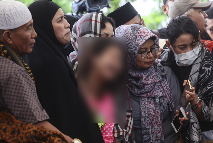   Korban selamat dalam kasus pembunuhan Pulomas Zanette Kalila (tengah) bersama Ibunya Almyanda Safira (kedua kiri) menghadiri pemakaman keluarga mereka yang tewas dalam kasus itu di TPU Tanah Kusir, Jakarta, Rabu (28/12). 