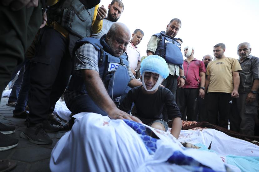 Koresponden Aljazirah Wael Dahdouh, tengah, berduka atas istri, putra, putri, dan cucunya, yang tewas dalam serangan udara Israel di kamp pengungsi Nuisserat, di luar rumah sakit di Deir al Balah, selatan Jalur Gaza, Kamis, 26 Oktober 2023.