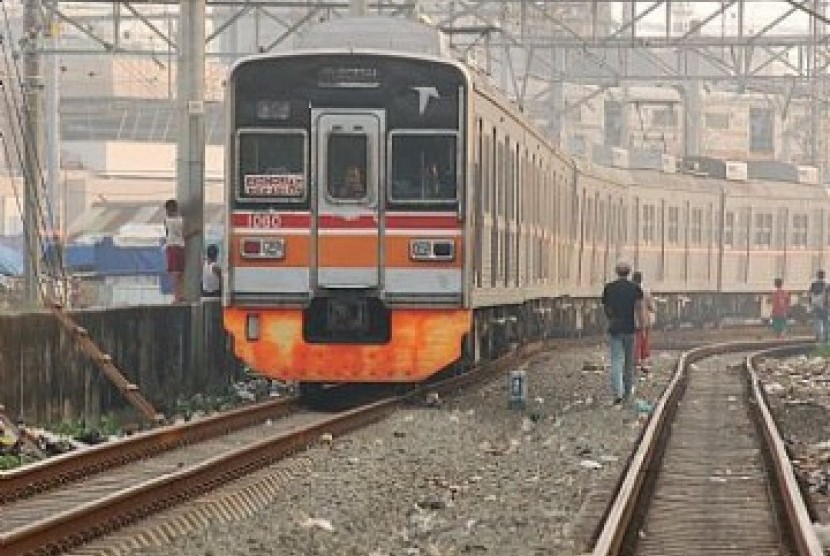 Kereta commuter line melintas disamping area pembangunan proyek peron Stasiun Buaran di Jakarta, Kamis (4/1).