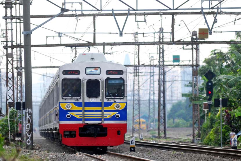  KRL Commuter Line melintas di kawasan Bukit Duri, Jakarta, Selasa (17/6). 