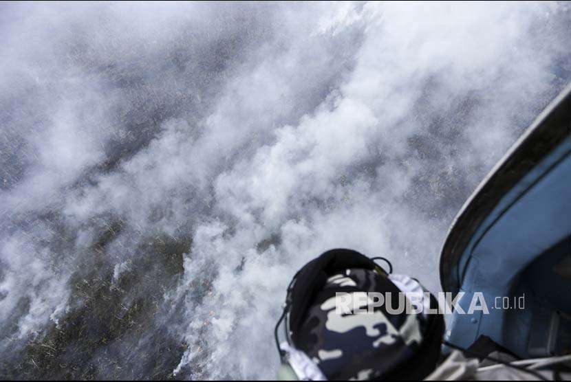 Kru helikopter MI-18Mtv-1 milik Badan Nasional Penanggulangan Bencana (BNPB) mengamati kepulan Asap yang membubung tinggi dari lahan yang terbakar di Pulu Beruang, Tulung Selapan, Ogan Komering Ilir (OKI), Sumatera Selatan, Kamis (13/9). BPBD Provinsi Sumatera Selatan masih berupaya melakukan pemadaman kebakaran yang terjadi sejak Rabu (12/9).