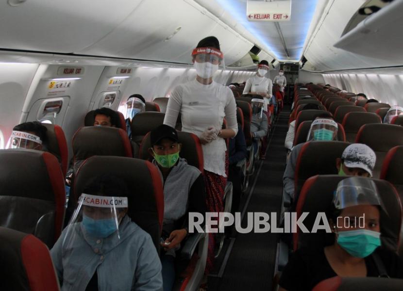 Pramugari dan penumpang pesawat memakai alat pelindung wajah dan masker. CDC AS menemukan bahwa hampir 11 ribu orang telah terpapar Covid-19 dalam penerbangan sejak Maret 2020.