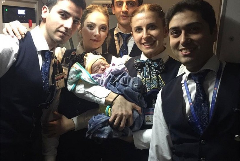 Kru pesawat Turkish Airlines memegang bayi Bennel yang lahir di dalam pesawat.