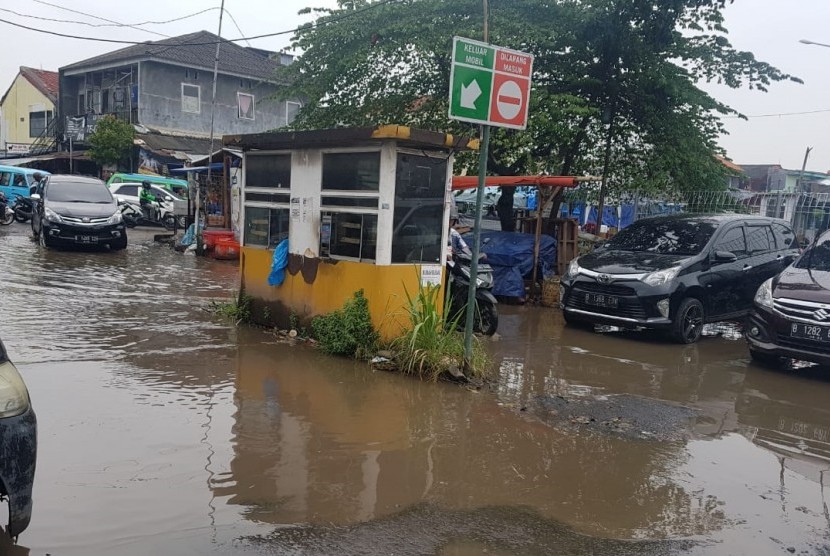 Kubangan air kotor menutup jalan masuk ke Stasiun Depok Baru, Depok, Jawa Barat, hari ini.