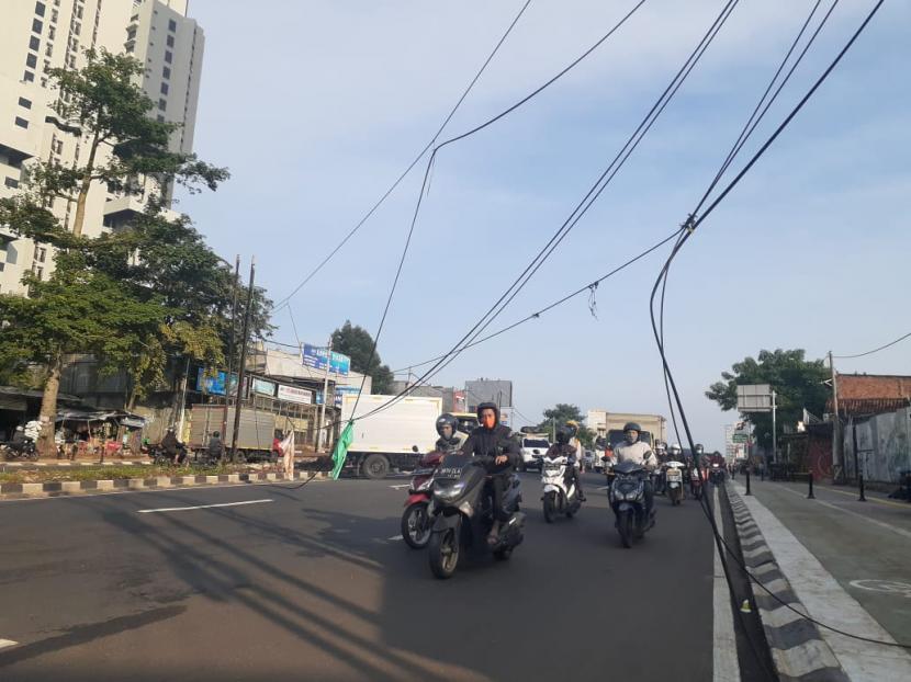 Kumpulan kabel berserakan menjuntai hingga ke permukaan aspal di Jalan Ciater Barat, Kecamatan Serpong, Tangerang Selatan, Senin (25/1). Arus lalu lintas di jalan tersebut menjadi terganggu.