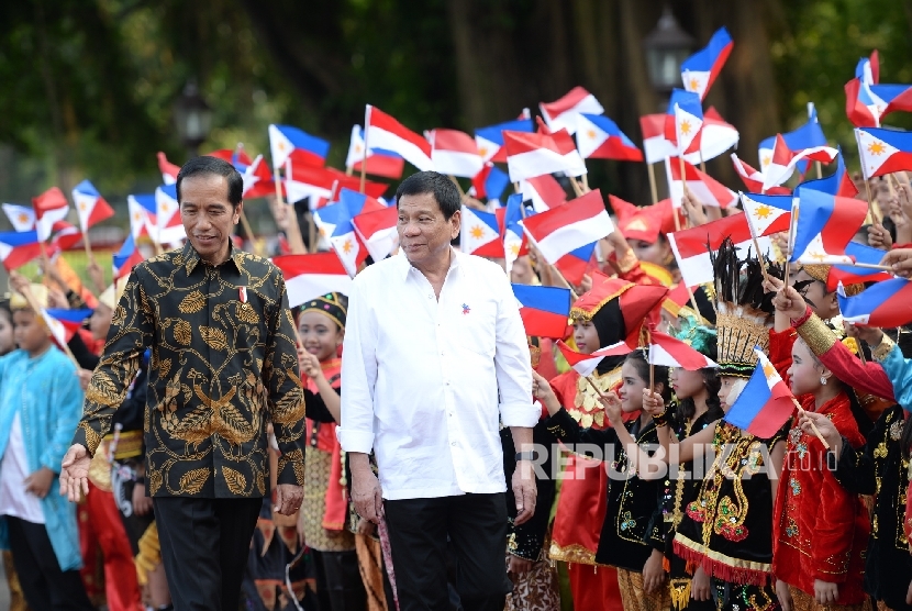 Kunjungan Rodrigo Duterte. Presiden Joko Widodo (kiri) bersama Presiden Filipina Rodrigo Duterte mendapat sambutan dari anak-anak dengan baju adat saat upacara penyambutan kunjungan kenegaraan di Istana Merdeka, Jakarta, Jumat (9/9). 