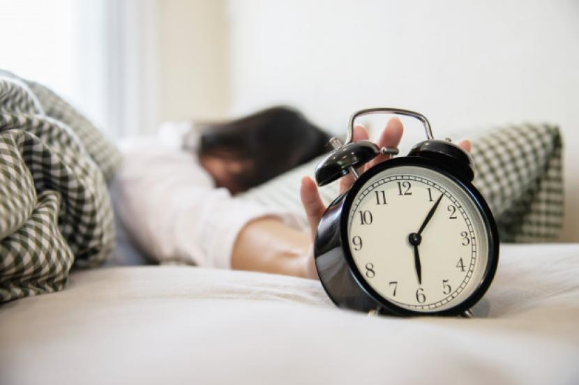 Seorang wanita mematikan alarm (ilustrasi). Jenia suara alarm ternyata berpengaruh pada kondisi setelah bangun tidur. Anda disarankan memilih jenis suara alarm terbaik untuk membangunkan tidur.