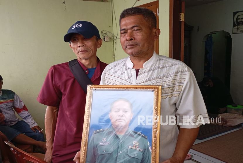 Oyib Gunawan (58 tahun) menunjukkan foto almarhum adiknya Mayor CPL Anda Rohanda di kediamannya di Kampung Sukasari RT  01 RW 02 Desa Cinunuk, Kecamatan Cileunyi, Kabupaten Bandung, Selasa (13/5/2025). Mayor CPL Anda Rohanda menjadi salah satu korban yang meninggal dunia saat proses pemusnahan amunisi tidak laik pakai di bibir pantai kawasan Desa Sagara, Kecamatan Cibalong, Kabupaten Garut, Senin (12/5/2025). 