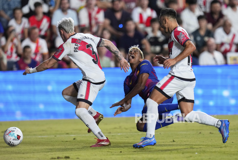 Lamine Yamal dari Barcelona (tengah) dilanggar hingga mengakibatkan penalti selama pertandingan sepak bola La Liga Spanyol antara Rayo Vallecano dan FC Barcelona di Stadion Vallecas di Madrid, Spanyol, Senin, 1 September 2025 dini hari WIB.