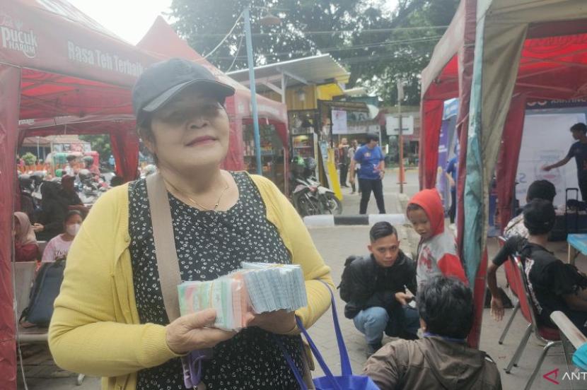 Lamriah (57 tahun), seorang penyedia jasa penukaran uang baru di Terminal Kalideres, Jakarta Barat pada Rabu (3/4/2024).