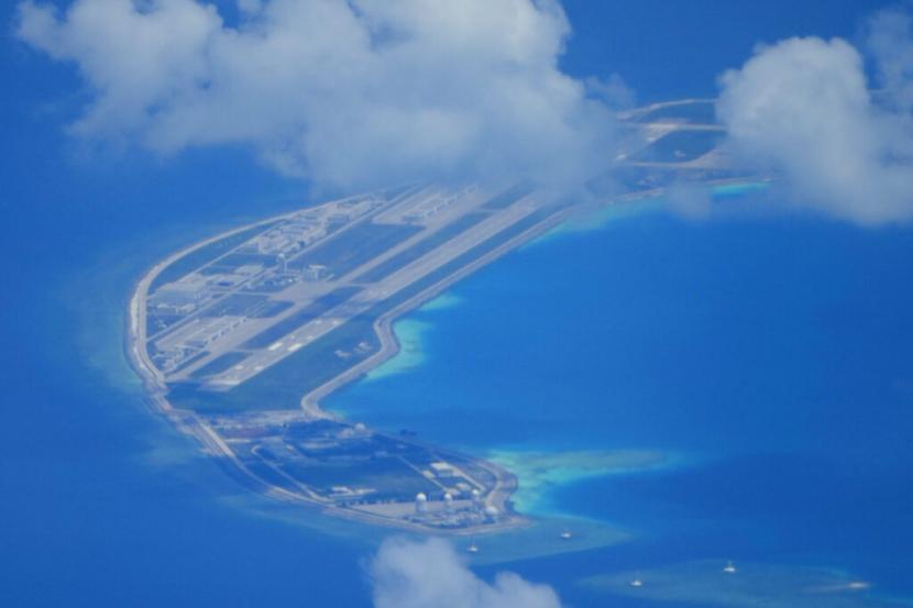 Landasan terbang buatan China terlihat di samping bangunan di pulau buatan di Mischief Reef di gugusan pulau Spratlys di Laut China Selatan terlihat pada Ahad.