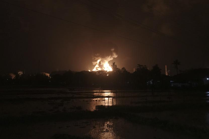 Langit bersinar dari api yang menghanguskan kilang minyak milik perusahaan minyak nasional Pertamina, di Cilacap, Jawa Tengah, Indonesia, Sabtu, 13 November 2021.