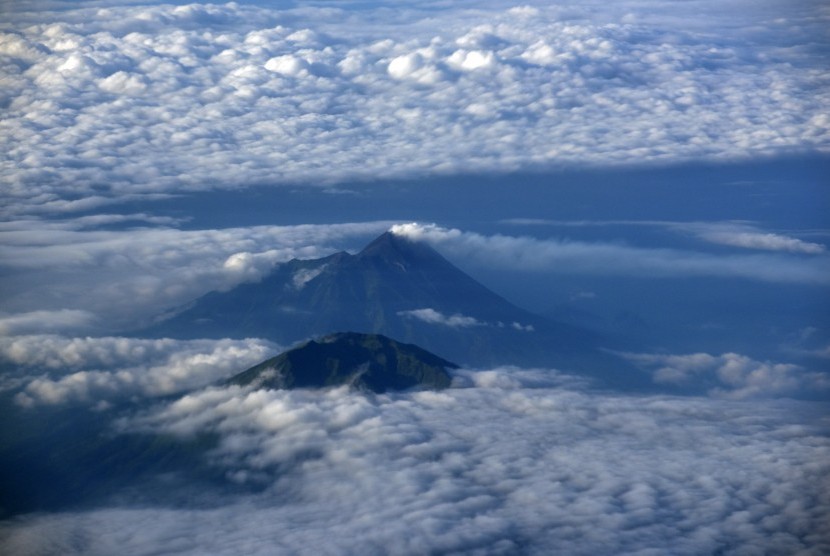 BTNGMb belum mencabut larangan pendakian ke Gunung Merbabu sampai akhir tahun. Foto: Lanskap Gunung Merapi yang mengeluarkan asap sulfatara dengan latar depan Gunung Merbabu terlihat udara Jawa Tengah, Selasa (17/5).