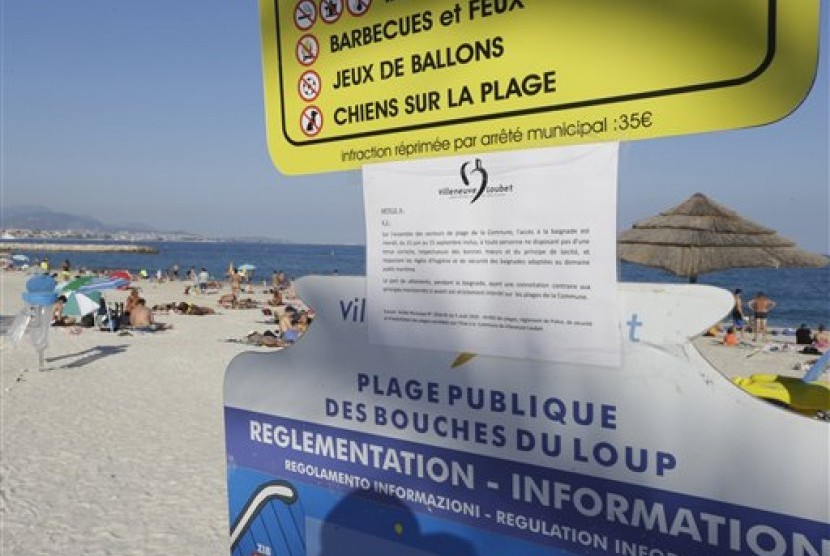 Larangan bagi perempuan menggunakan burkini ditempel di papan informasi di pantai di Villeneuve-Loubet, French Riviera, Prancis. 