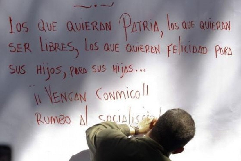 Late Venezuelan President Hugo Chavez writes a message after signing his support for a proposal to change the constitution, in Caracas in this December 11, 2008 file photo.