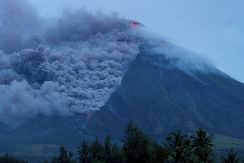 Lava mengalir dari gunung berapi Mayon, seperti terlihat dari Desa Busay, Legazpi, 340 kilometer dari Manila, Filipina, Selasa (16/1). Sebanyak 9.000 orang telah mengungsi.