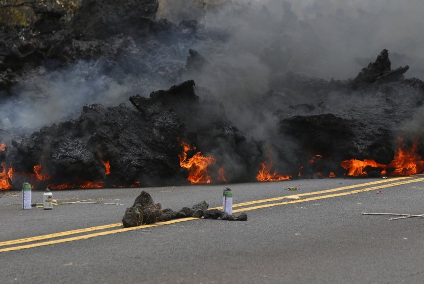 Lava yang terbakar meluber ke jalanan di kawasan Leilani Estates dekat Pahoa. Warga Hawaii percaya lava sebagai persembahan bagi Dewi Volkano.