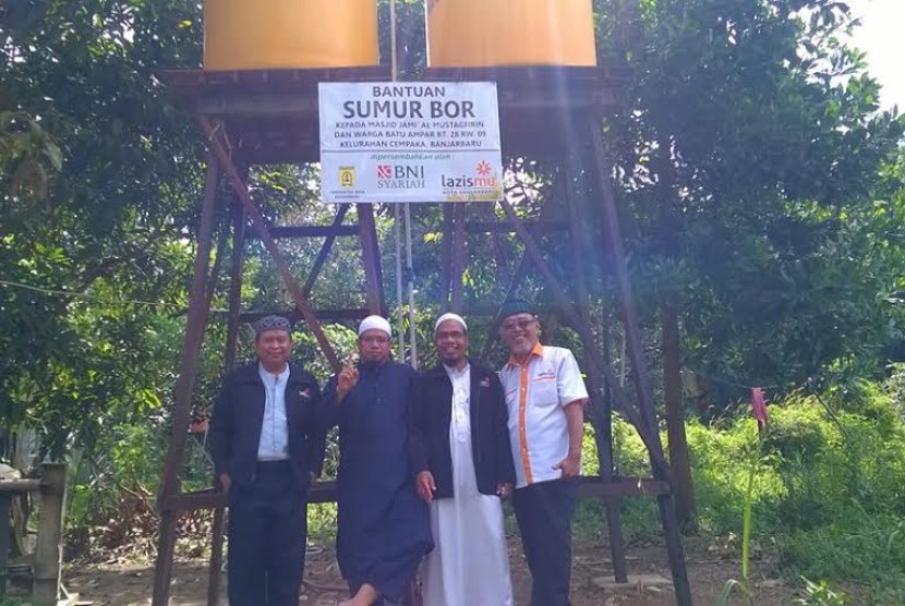 Lazismu menyerahkan bantuan sumur bor kepada masjid terpencil di Kalimantan.