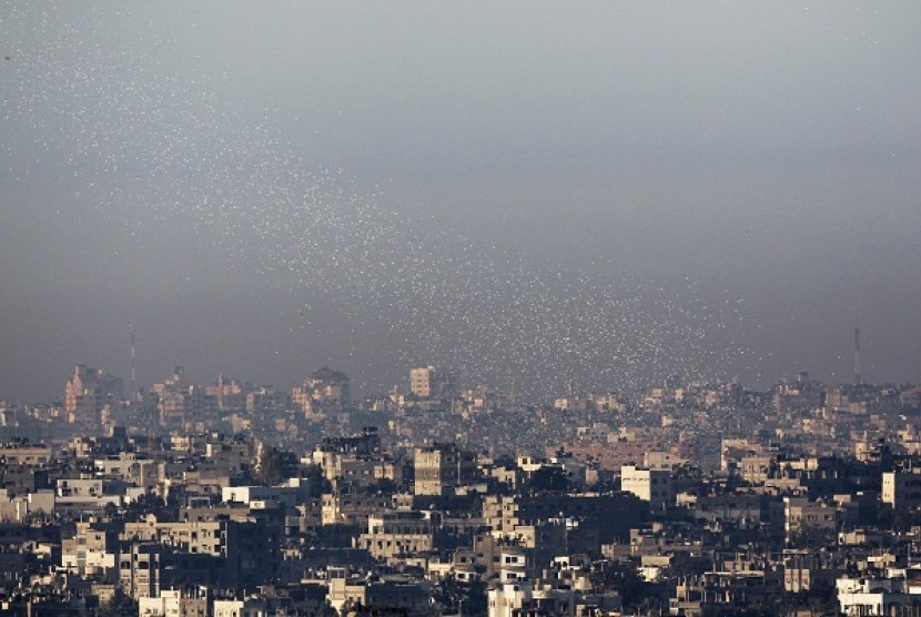 Leaflets, dropped by Israeli warplanes, telling residents to keep their distance from militants and Hamas facilities fall over Gaza, as seen from Netiv Haasara, just outside the northern Gaza Strip November 15, 2012. 