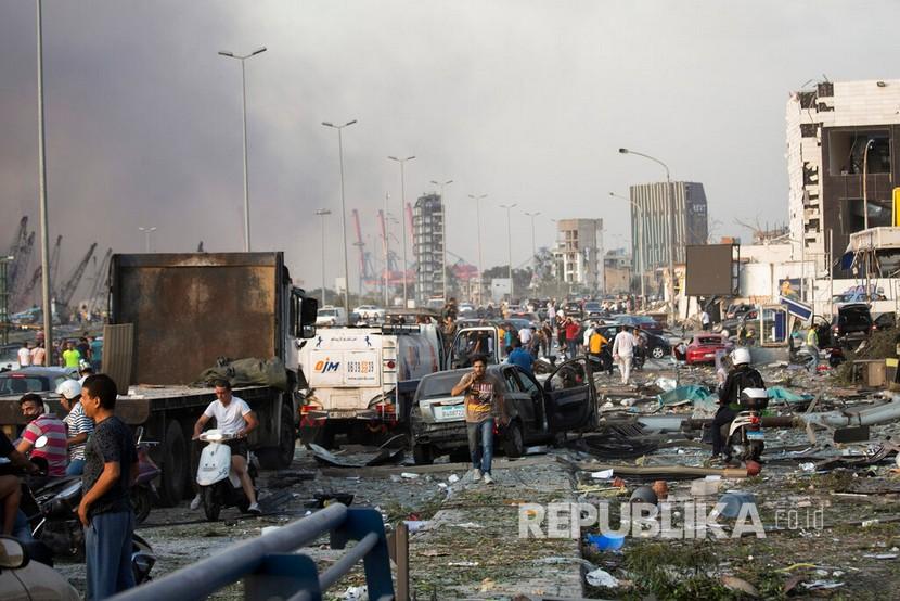  Warga mengevakuasi korban dari lokasi ledakan di pelabuhan i Beirut, Lebanon, Selasa (4/8) waktu setempat.