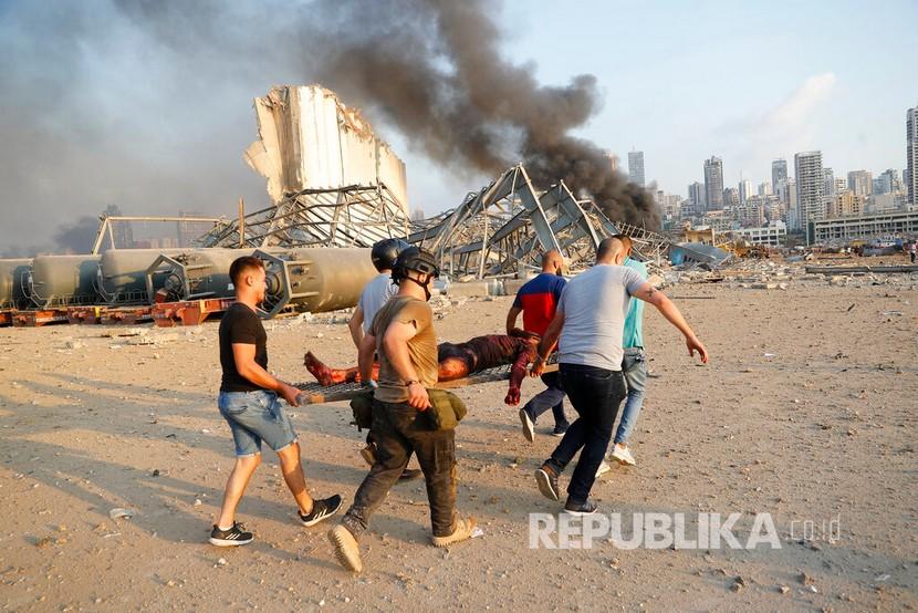 Warga mengevakuasi korban dari lokasi ledakan di pelabuhan di Beirut, Lebanon, Selasa (4/8) waktu setempat.