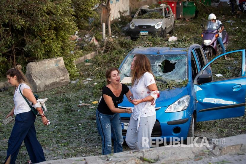    Warga yang terluka akibat ledakan meninggalkan lokasi kejadian di Beirut, Lebanon, Selasa (4/8) waktu setempat.
