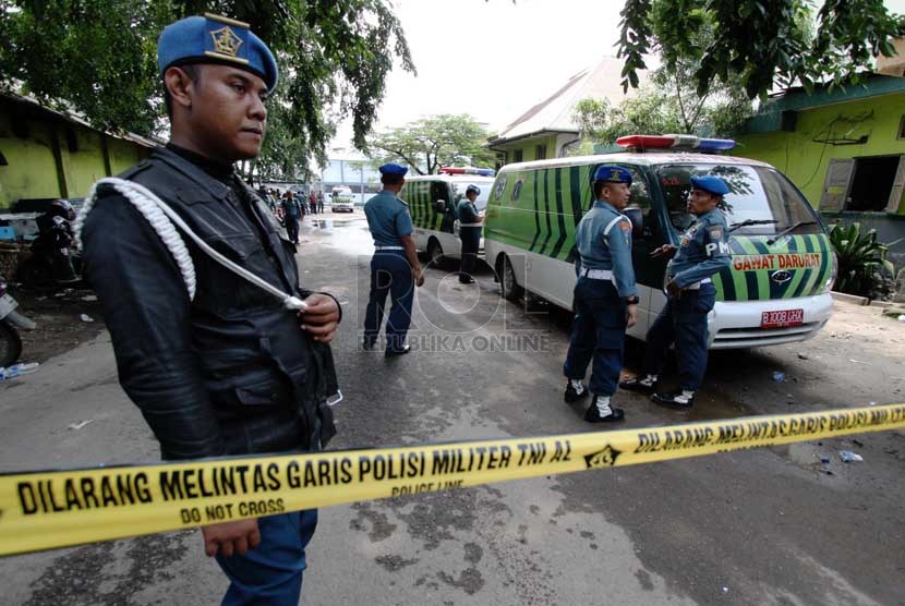   Petugas berjaga di depan gerbang dermaga gudang Amunisi Satuan Komando Pasukan Katak yang hancur akibat ledakan di Kawasan Armada Barat di Pondok Dayung, Jakarta Utara, Rabu (5/3).    (Republika/Yasin Habibi)
