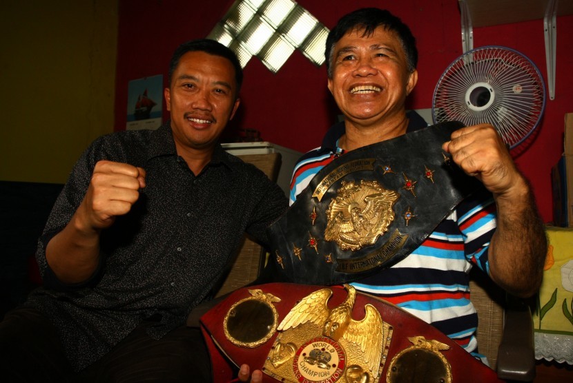 Legendaris Petinju Indonesia Ellyas Pical (kanan) menunjukkan sabuk Juara Dunia Tinju yang diperolehnya kepada Menteri Pemuda dan Olahraga Imam Nahrawi (kiri) yang berkunjung ke kediamannya di Tangerang, Banten, Jumat (10/3).