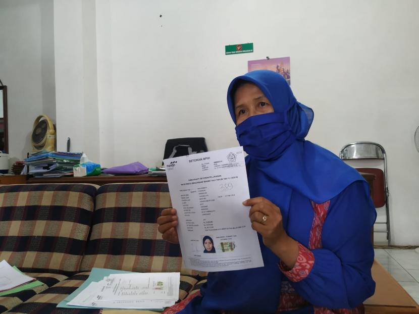 BPKH : Tambahan Insentif Masuk Virtual Account Jamaah Haji. Foto: Leni Yurlaeni (54), salah seorang calon jamaah haji asal Kota Tasikmalaya yang gagal berangkat pada tahun ini, menunjukan dokumen pelunasan biaya haji, Rabu (3/6).