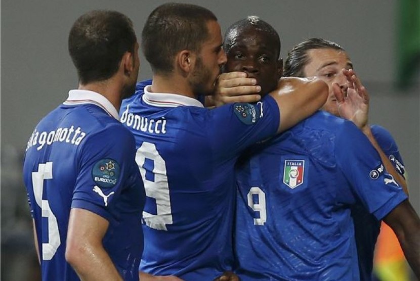 Leonardo Bonucci (dua kiri), pemain timnas Italia, menutup mulut striker Mario Balotelli yang melakukan selebrasi usai menjebol jala Republik Irlandia di laga Grup C Piala Eropa 2012. 