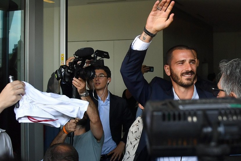 Leonardo Bonucci melambaikan tangan kepada fan saat keluar dari kantor AC Milan, di Milan, Italia, Jumat (14/7).