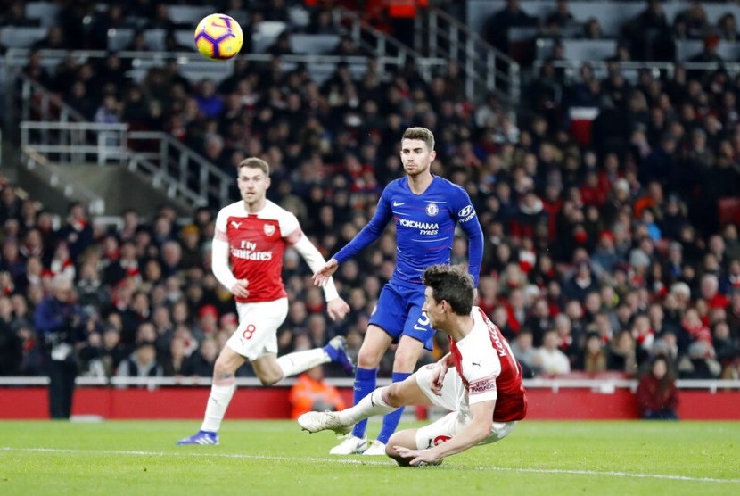 Leurent Koscielny menjatuhkan badan saat mencetak gol kedua Arsenal ke gawang Chelsea.
