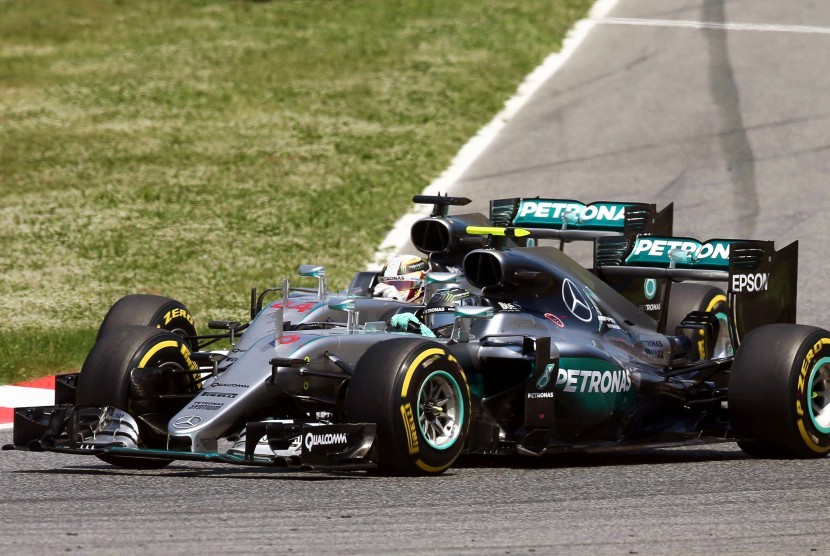 Lewis Hamilton (belakang) dari Mercedes AMG GP bersama rekan satu timnya Nico Rosberg (depan) saling menempel pada awal balapan di sirkuit Barcelona-Catalunya di Montmelo, Barcelona, spanyol, Ahad (15/5)