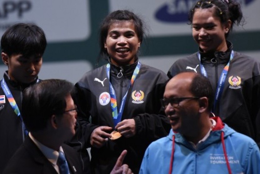Lifter Indonesia Sri Wahyuni (tengah) dan Yolanda Putri (kanan) serta lifter Thailand Chirapan Nanthawong (kiri) usai menerima medali di nomor putri 48 kg A di venue angkat besi 18th Asian Games Invitation Tournament di JiExpo, Jakarta, Ahad (11/2). 
