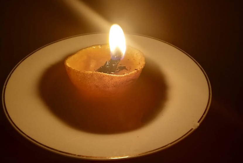 Lilin dari kulit jeruk dan gelas digunakan warga Kota Bandung saat listrik PLN mati.