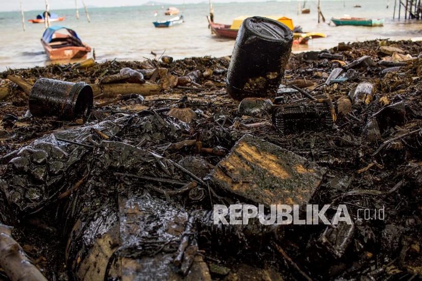 Limbah minyak hitam mencemari pantai utara Pulau Batam di Kepulauan Riau, Selasa (05/01/2021). Menurut Dinas Lingkungan Hidup (DLH) Kota Batam, setiap musim angin utara daerah pesisir Batam kerap tercemar limbah minyak hitam yang berasal dari alur pelayaran dan terbawa arus laut internasional. 