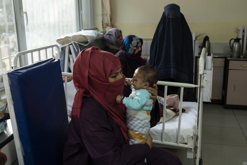 Lina menggendong bayi laki-lakinya, Osman, saat ia menjalani perawatan di bangsal gizi buruk Rumah Sakit Anak Nasional Ataturk di Kabul, Afghanistan, Kamis, 2 Desember 2021. Menurut angka PBB dari awal November, hampir 24 juta orang di Afghanistan, sekitar 60% persen dari populasi, menderita kelaparan akut, termasuk 8,7 juta yang hidup di dekat kelaparan.