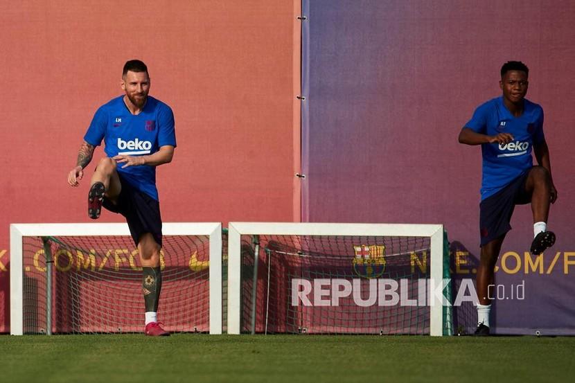  Lionel Messi (kiri) dan Ansu Fati saat berlatih bersama di Barcelona.