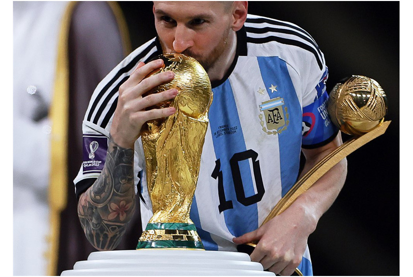  Lionel Messi dari Argentina mencium trofi setelah memenangkan Final Piala Dunia FIFA 2022 antara Argentina dan Prancis di stadion Lusail, Qatar,  Ahad (18/12/2022).