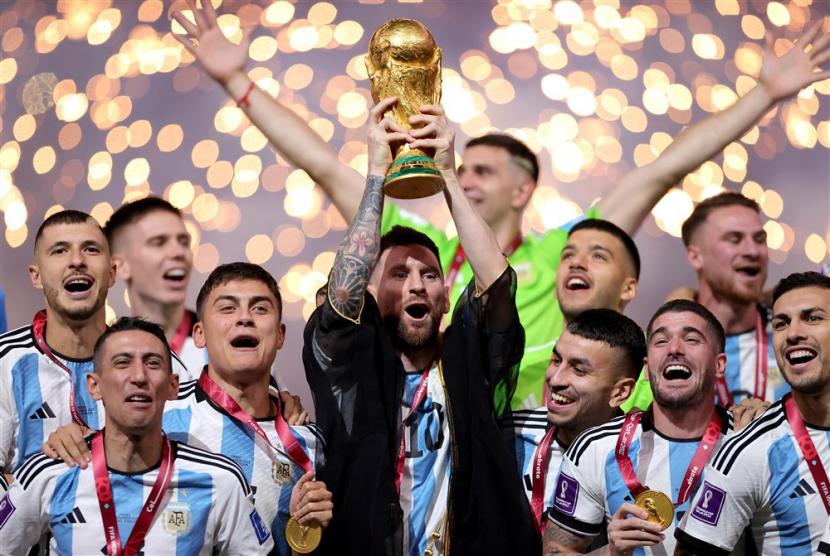  Lionel Messi dari Argentina mengangkat trofi setelah Argentina memenangkan final Piala Dunia FIFA 2022 (ilustrasi). Piala Dunia 2026 akan digelar di tiga negara, AS, Meksiko, dan Kanada, dengan ketiga tuan rumah lolos langsung ke putaran final.