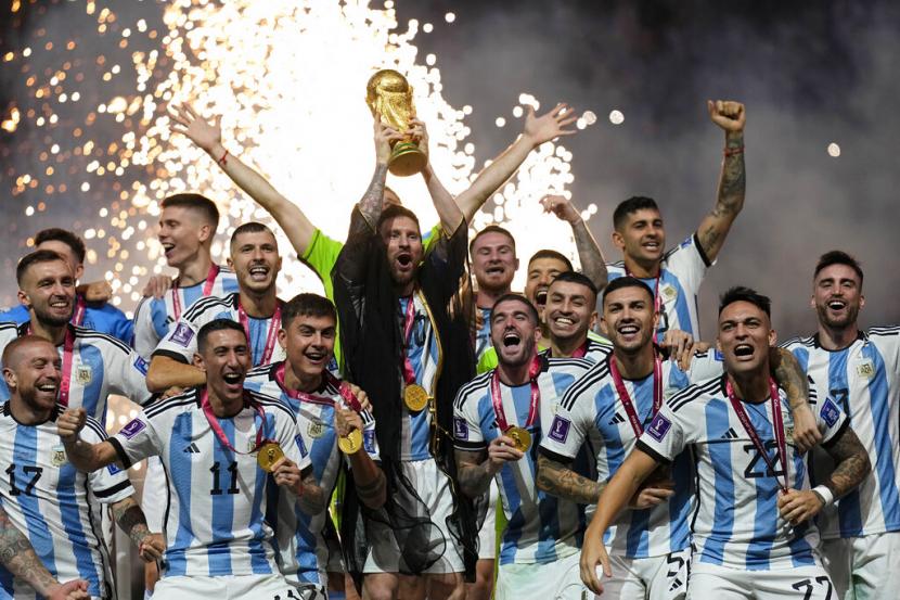  Lionel Messi dari Argentina mengangkat trofi setelah memenangkan pertandingan sepak bola final Piala Dunia antara Argentina dan Prancis di Stadion Lusail di Lusail, Qatar, Ahad (18/12/2022).