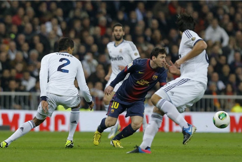 Lionel Messi (dua kanan), striker Barcelona, dikepung pemain Real Madrid saat laga pertama semifinal Copa del Rey di Santiago Bernabeu, Madrid, Rabu (30/1). 