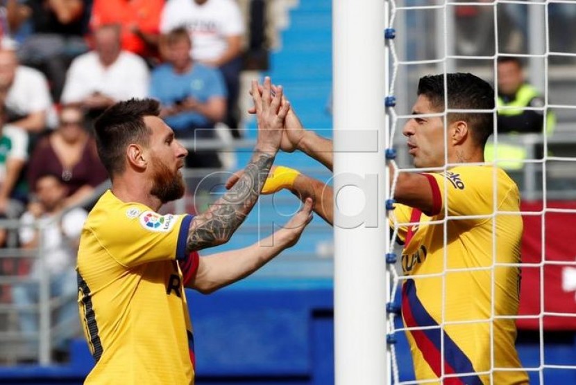 Lionel Messi (kiri) dan Luis Suarez merayakan gol.