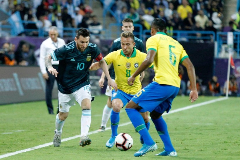 Lionel Messi (kiri) dijaga dua pemain Brasil.