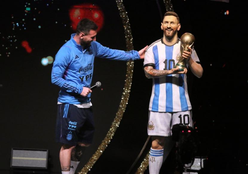 Lionel Messi (kiri) memegang patung dirinya yang ada di Paraguay, Selasa (28/3/2023). 