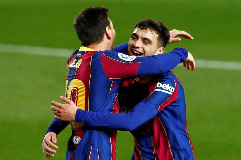 Lionel Messi (kiri) memeluk Pedri saat keduanya masih sama-sama membela Barcelona.