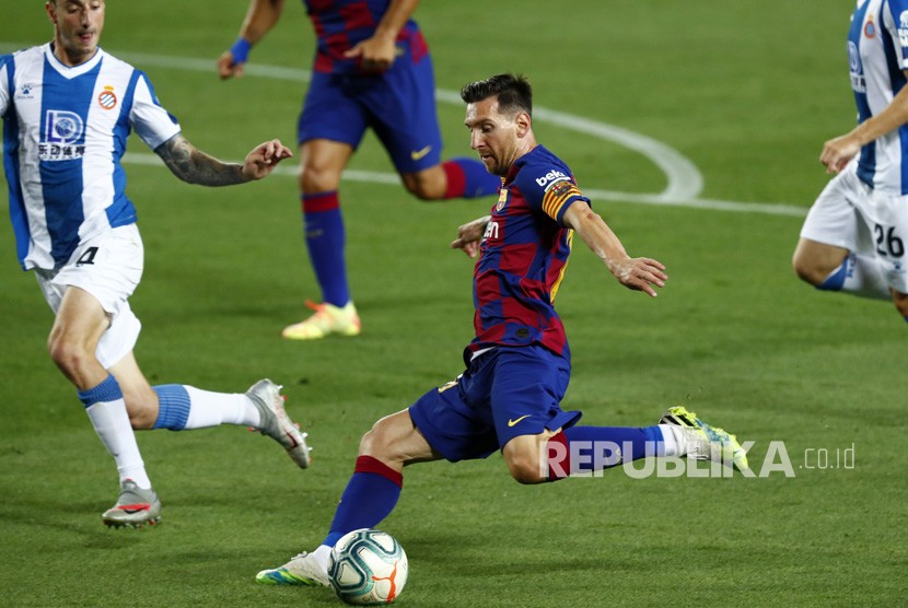 Bintang Barcelona Lionel Messi (tengah) menendang bola.