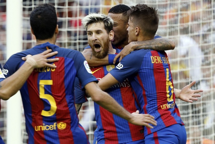 Lionel Messi (tengah) dikelilingi pemain Barcelona, salah satunya Denis Suarez (kanan).