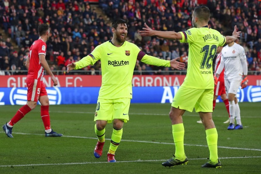 Lionel Messi (tengah) setelah mencetak gol ke gawang Girona.