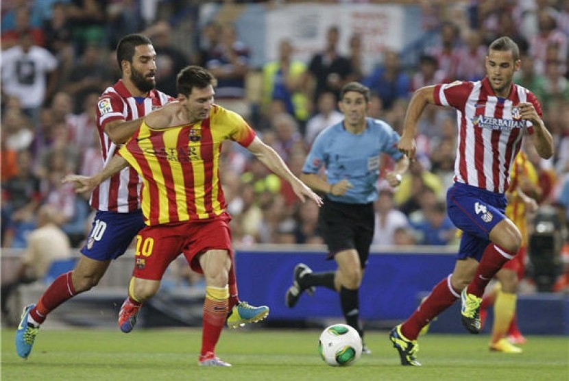 Lionel Messi (tengah), striker andalan Barcelona, menggiring bola saat menghadapi Atletico Madrid di leg pertama Piala Super Spanyol di Vicente Calderon, Madrid, Rabu (21/8). 